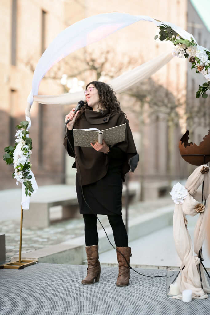 Nadine Amalea-Traurednerin und Sängerin singt vor einem Traubogen