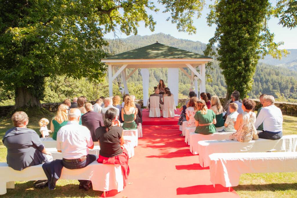 Traurednerin Nadine Amalea im Schloss Eberstein mit Gästen, rotem Teppich und einer Pergola